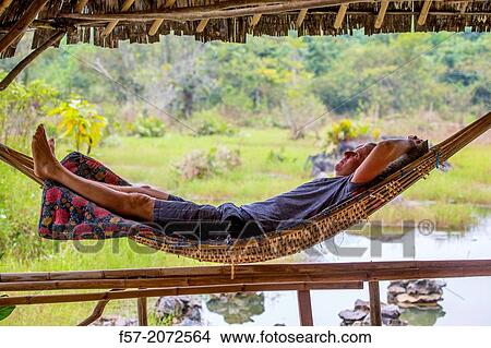 Tourist relaxes in a bamboo hammock, Vang Vieng, Laos. View Large Photo Image Picture - Tourist relaxes in a bamboo hammock, Vang Vieng, Laos.. Fotosearch