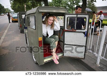 Stock Photograph - Tourist riding in cycle rickshaw, Hutong District, Beijing, China, Asia. Fotosearch