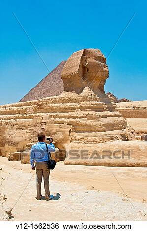 Tourist shooting video at Great Sphinx and Pyramid of Giza View Large Photo Image Stock Photograph - Tourist shooting video at Great Sphinx and Pyramid of Giza. Fotosearch