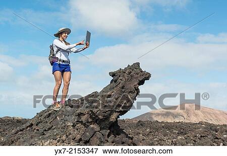 Stock Photo - Tourist using a Tablet at Timanfaya National Park, Lanzarote, Canary Islands, Spain.. Fotosearch