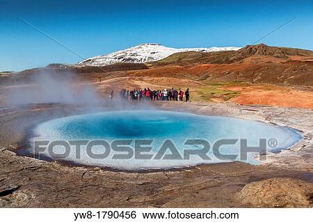 Stock Photograph - Tourist waiting for Strokkur geyser to erupt, Iceland Strokkur is a fountain geyser in the geothermal area beside the Hvita River It is one of Iceland's most famous geysers, erupting about every 4-8 minutes and 15 - 20 m high, sometimes up to 40 m high. Fotosearch