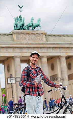 Tourist with bike and guide book in Brandenburg Gate, Berlin, Germany View Large Photo Image Picture - Tourist with bike and guide book in Brandenburg Gate, Berlin, Germany. Fotosearch