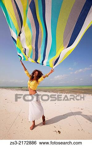 Tourist woman holding a colorful scarf at the beach, Jambiani, Zanzibar Island, Tanzania, Indian Ocean, East Africa. View Large Photo Image Stock Photograph - Tourist woman holding a colorful scarf at the beach, Jambiani, Zanzibar Island, Tanzania, Indian Ocean, East Africa.. Fotosearch