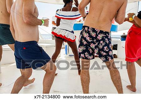 Stock Image - Tourists and entertainer dancing, on a catamaran, journey in Saona island, Dominican Republic.. Fotosearch
