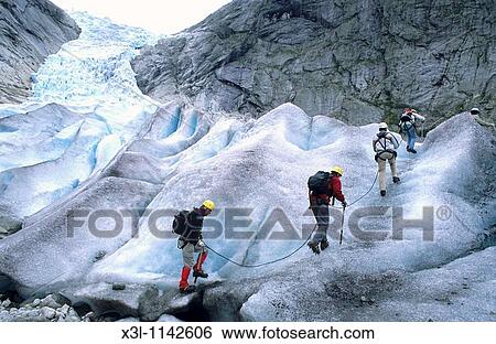 Stock Photograph - Tourists climb up Nigardsbreen glacier National Park of Jostedalbreen Norway. Fotosearch