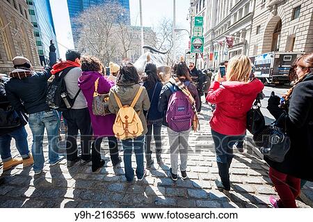 Tourists cluster around and pose for photos in front of the Wall Street Bull, by artist Arturo DiModica, on Broadway in Lower Manhattan in New York View Large Photo Image Stock Photography - Tourists cluster around and pose for photos in front of the Wall Street Bull, by artist Arturo DiModica, on Broadway in Lower Manhattan in New York. Fotosearch