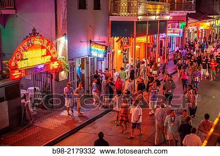Tourists crowd Bourbon Street in New Orleans? French Quarter at twilight, looking for nightlife. View Large Photo Image Stock Image - Tourists crowd Bourbon Street in New Orleans? French Quarter at twilight, looking for nightlife.. Fotosearch
