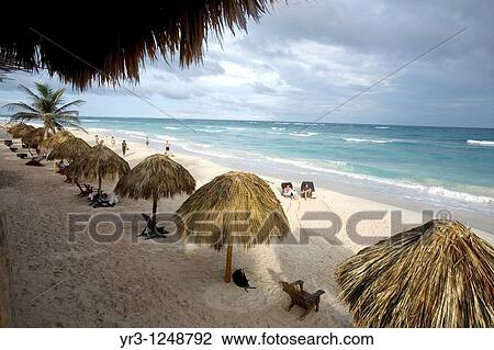Stock Image - Tourists gather on a beach along the Mayan Riviera in the ancient Mayan city of Tulum in Mexico's Yucatan Peninsula.. Fotosearch