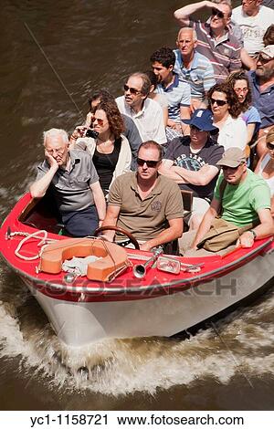 tourists in a little boat in Bruges, Belgium View Large Photo Image Stock Image - tourists in a little boat in Bruges, Belgium. Fotosearch
