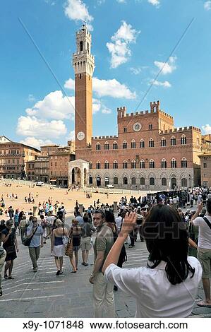 Tourists in the Piazza del Campo, the central square of the city of Sienna, Tuscany, Italy Torre del Mangia tower rises behind View Large Photo Image Stock Photo - Tourists in the Piazza del Campo, the central square of the city of Sienna, Tuscany, Italy Torre del Mangia tower rises behind. Fotosearch