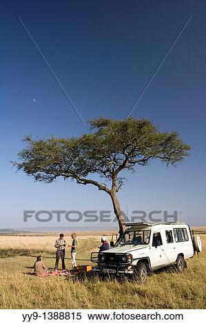 Stock Photography - Tourists On Safari having Picnic - Masai Mara National Reserve, Kenya. Fotosearch