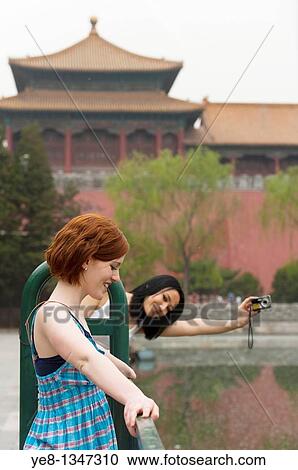 Stock Image - Tourists, one taking photos of the other, The Forbidden City, Beijing, China, Asia MR. Fotosearch