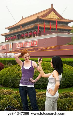 Tourists, one taking photos of the other, in front of The Gate of Heavenly Peace, The Forbidden City, Beijing, China, Asia MR View Large Photo Image Stock Photograph - Tourists, one taking photos of the other, in front of The Gate of Heavenly Peace, The Forbidden City, Beijing, China, Asia MR. Fotosearch
