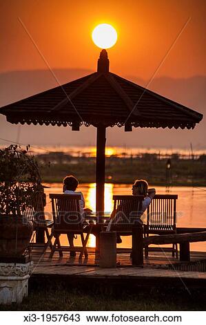Tourists relaxing during a sunset over Inle Lake, Nyaung Shwe, Shan State, Myanmar, (Burma). View Large Photo Image Stock Image - Tourists relaxing during a sunset over Inle Lake, Nyaung Shwe, Shan State, Myanmar, (Burma).. Fotosearch