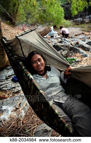 Tourists sleeping in hammocks along the O Chbar river. Dey Ei Trek, Mondulkiri, Cambodia. View Large Photo Image Picture - Tourists sleeping in hammocks along the O Chbar river. Dey Ei Trek, Mondulkiri, Cambodia.. Fotosearch
