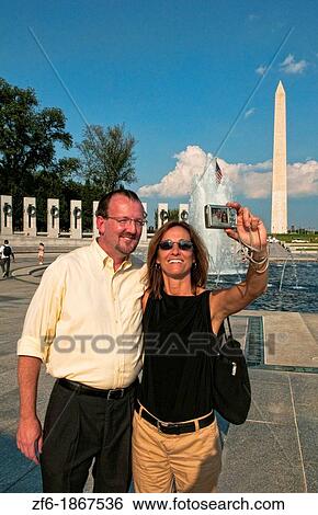 Tourists taking self photo at New National World War II Memorial on the Mall in Washington DCin the USA honoring the heros of WWII in Europe war View Large Photo Image Stock Photograph - Tourists taking self photo at New National World War II Memorial on the Mall in Washington DCin the USA honoring the heros of WWII in Europe war. Fotosearch