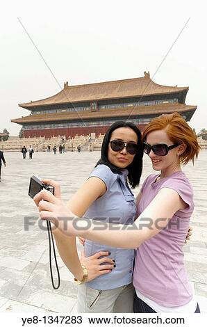 Stock Image - Tourists taking their own photograph in front of the Hall for Worship Of Ancestors, The Forbidden City, Beijing, China, Asia MR. Fotosearch