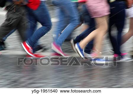 Stock Image - tourists walking in rain in rome, italy.. Fotosearch