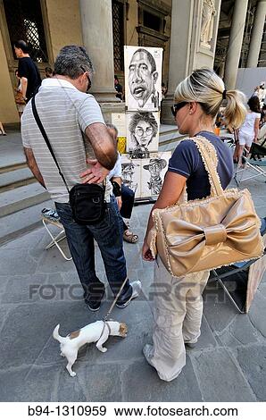 Stock Photo - Tourists with dog watching cartoons on the street. Florence, Tuscany. Italy.. Fotosearch