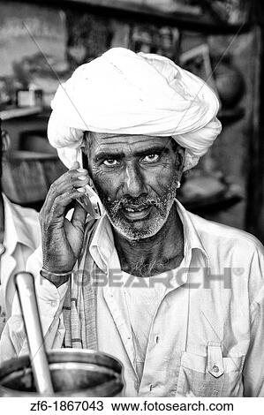 Traditional Hindu vendor man with white turban portrait using modern technology cell phone in Jaipur Rajasthan India View Large Photo Image Stock Image - Traditional Hindu vendor man with white turban portrait using modern technology cell phone in Jaipur Rajasthan India. Fotosearch