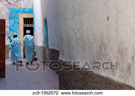 Traditional musicians walking by an alleyway in Essaouira medina, Morocco. View Large Photo Image Stock Image - Traditional musicians walking by an alleyway in Essaouira medina, Morocco.. Fotosearch