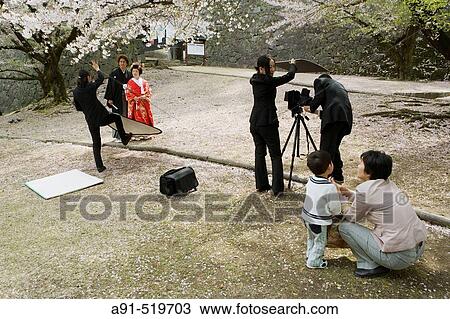 Stock Image - Traditional wedding photo in the castle park under the blossoming sherries constructed by the Kato Clan in 1607 City of Kumamoto Island of Kyushu Japan. Fotosearch