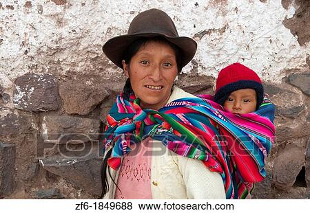 Traditional woman in dress and hat with baby on back in small town of Pisaq Peru View Large Photo Image Stock Photo - Traditional woman in dress and hat with baby on back in small town of Pisaq Peru. Fotosearch