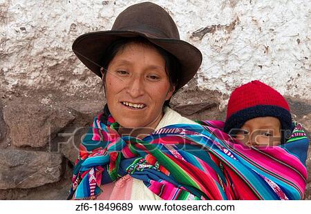 Traditional woman in dress and hat with baby on back in small town of Pisaq Peru View Large Photo Image Stock Photo - Traditional woman in dress and hat with baby on back in small town of Pisaq Peru. Fotosearch