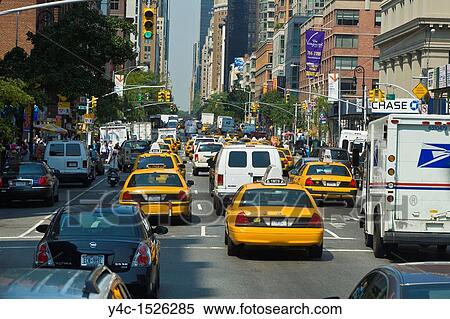 Stock Photography - Traffic and pedestrians on crowded city streets in Manhattan in New York City. Fotosearch