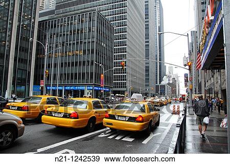 Stock Photo - Traffic in front of the Radio City Music Hall. Avenue of the Americas (Sixth Avenue). Midtown Manhattan, New York, New York. USA.. Fotosearch