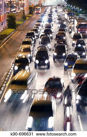 Traffic jam besides of a bus lane with an express city bus during the evening rush hour when everybody goes home on the main thoroughfare of Jakarta, Jalan Sudirman, in the heart of the Central Business District, Jakarta, Southeast Asia View Large Photo Image Stock Image - Traffic jam besides of a bus lane with an express city bus during the evening rush hour when everybody goes home on the main thoroughfare of Jakarta, Jalan Sudirman, in the heart of the Central Business District, Jakarta, Southeast Asia. Fotosearch