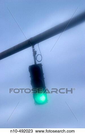 Traffic light, on green, hanging over a city street View Large Photo Image Stock Image - Traffic light, on green, hanging over a city street. Fotosearch