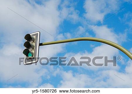 Traffic lights on green isolated against sky View Large Photo Image Stock Photograph - Traffic lights on green isolated against sky. Fotosearch