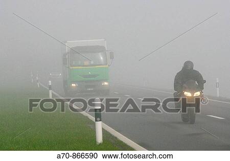 Traffic truck faert with light behind a motorcycle in the dense fog View Large Photo Image Stock Image - Traffic truck faert with light behind a motorcycle in the dense fog. Fotosearch