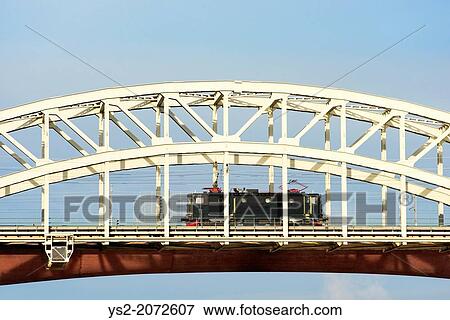 Stock Photo - Train engine passing on a railway bridge. Stockholm, Sweden.. Fotosearch
