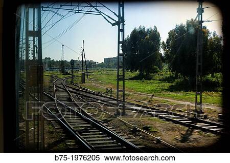 Stock Photography - train tracks and telecommunications and electricity towers seen through the window of a train. Fotosearch