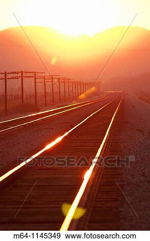 Train tracks into the sunset View Large Photo Image Stock Photo - Train tracks into the sunset. Fotosearch