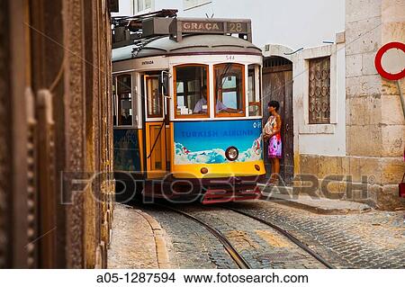 Tram 28 -known by the Portuguese as the electric tram - is going down Rua Sao Vicente in Alfama district, moving toward the lower area of Lisbon, Portugal. View Large Photo Image Picture - Tram 28 -known by the Portuguese as the electric tram - is going down Rua Sao Vicente in Alfama district, moving toward the lower area of Lisbon, Portugal.. Fotosearch