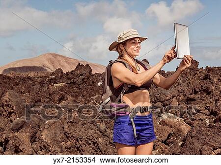 Traveler using a tablet at Timanfaya National Park, Lanzarote, Canary Islands, Spain. View Large Photo Image Picture - Traveler using a tablet at Timanfaya National Park, Lanzarote, Canary Islands, Spain.. Fotosearch