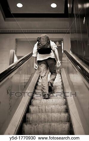 traveller climbing up an escalator, a man with backpack, Cornavin - main railway station in Geneva, Switzerland View Large Photo Image Stock Image - traveller climbing up an escalator, a man with backpack, Cornavin - main railway station in Geneva, Switzerland. Fotosearch