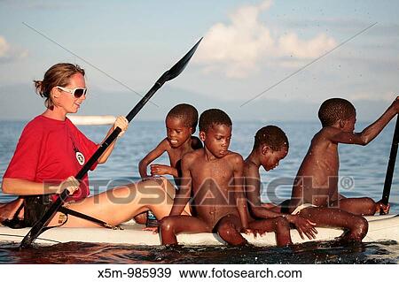 Traveller on a Kayak in Lake Malawi with local children View Large Photo Image Stock Photo - Traveller on a Kayak in Lake Malawi with local children. Fotosearch