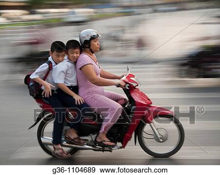 Stock Photo - Travellers on two wheelers in Ho Chi Minh City, Vietnam. Fotosearch