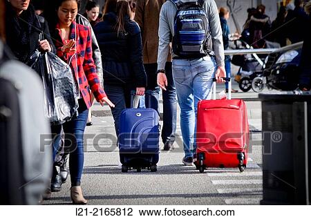 Travellers, tourists. Couple crossing a street with luggage wheels. Barcelona, Catalonia, Spain. View Large Photo Image Stock Image - Travellers, tourists. Couple crossing a street with luggage wheels. Barcelona, Catalonia, Spain.. Fotosearch