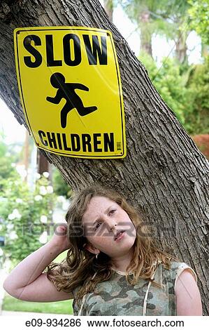 tree trunk with? Slow Children? sign, girl in front of tree with puzzled expression and body language View Large Photo Image Stock Photograph - tree trunk with? Slow Children? sign, girl in front of tree with puzzled expression and body language. Fotosearch