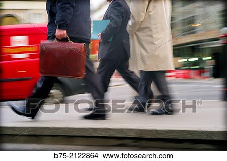 tree unrecognizable executive with portfolio walking hurriedly in the city with traffic in London, England, UK, Europe View Large Photo Image Picture - tree unrecognizable executive with portfolio walking hurriedly in the city with traffic in London, England, UK, Europe. Fotosearch