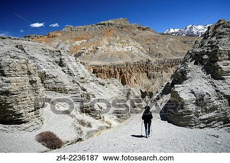 Trekker and mineral landscape between Lo Manthang and the village of Dhie Gaon. Nepal, Gandaki, Upper Mustang (near the border with Tibet). Model Released. View Large Photo Image Stock Photo - Trekker and mineral landscape between Lo Manthang and the village of Dhie Gaon. Nepal, Gandaki, Upper Mustang (near the border with Tibet). Model Released.. Fotosearch