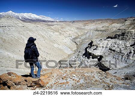 Trekker and mineral landscape between Lo Manthang and the village of Dhie Gaon. Nepal, Gandaki, Upper Mustang (near the border with Tibet). Model Released. View Large Photo Image Stock Photograph - Trekker and mineral landscape between Lo Manthang and the village of Dhie Gaon. Nepal, Gandaki, Upper Mustang (near the border with Tibet). Model Released.. Fotosearch