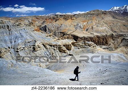 Trekker and mineral landscape between Lo Manthang and the village of Dhie Gaon. Nepal, Gandaki, Upper Mustang (near the border with Tibet). Model Released. View Large Photo Image Stock Photograph - Trekker and mineral landscape between Lo Manthang and the village of Dhie Gaon. Nepal, Gandaki, Upper Mustang (near the border with Tibet). Model Released.. Fotosearch
