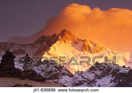 Stock Photo - Trekker at dawn on Kangchenjunga (8595 metres), Talung face from Dzong Ri, Sikkim, India. Most easterly of the 8000 metre peaks.. Fotosearch