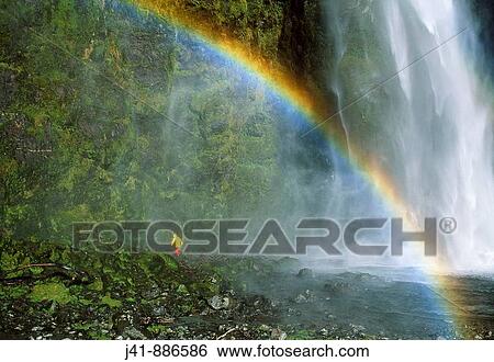 Stock Photograph - Trekker heading behind Sutherland Falls Milford Track Fiordland National Park New Zealand. Fotosearch